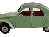 une petite voiture verte posée sur une surface blanche