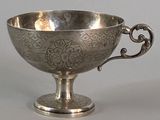 a silver cup with a handle on a table
