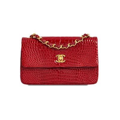 a red crocodile skin bag with a gold chain