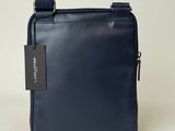 the small blue bag is sitting on a white surface
