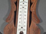 a wooden clock with a thermometer attached to it