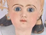 a doll head with a pair of shoes on top of it