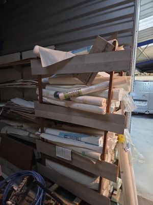 de nombreux rouleaux de papier empilés sur une palette dans un entrepôt