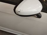 a side view mirror of a white car with black trims