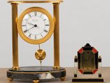 a clock that is sitting on a table next to a small clock