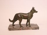 bronze statue of a dog on a marble base on a white background