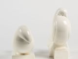 pair of white ceramic bird figurines on marble bases