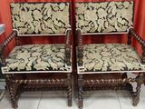 two wooden chairs with floral upholstered cushions in a room
