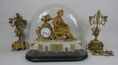 une horloge en or sous un dôme de verre sur une table