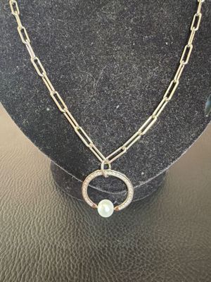 un gros plan d'un collier sur un mannequin, avec une chaîne