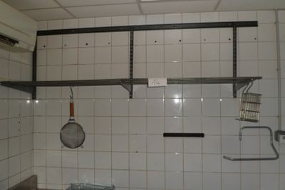 une petite cuisine avec du carrelage blanc aux murs