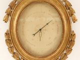 a clock that is on the wall with a gold frame