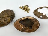three pieces of bronze are shown on a white surface