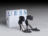 une paire de chaussures noires à talons hauts posée à côté d'une boîte