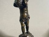 une statue en bronze représentant un garçon tenant un ballon de basket