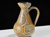 un vase jaune et blanc posé sur une table blanche