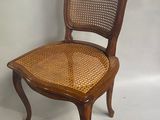 une image représentant une chaise en bois avec une assise en osier sur fond blanc