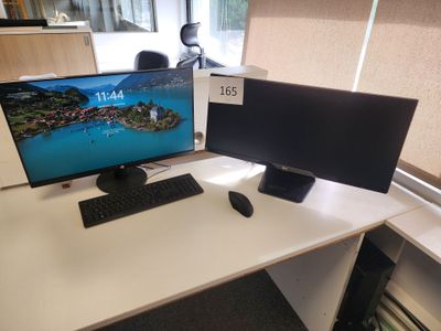 un écran d'ordinateur posé sur un bureau avec un clavier et une souris
