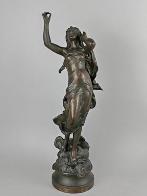 an antique bronze statue of a woman holding a bird in her hand