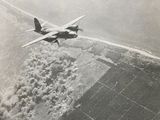 an old photo of a plane flying in the sky