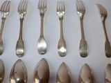 a lot of silver spoons and forks on a table