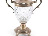 une coupe ancienne en métal argenté, accompagnée d'une cuillère posée sur un socle