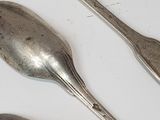 five spoons and two spoons sitting on a table
