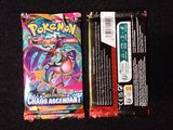 two packs of pokemon cards sitting on top of a black surface