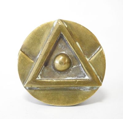 une image représentant une plaque en laiton ornée d'un motif pyramidal