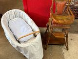 un bébé dans un panier posé à côté d'un fauteuil à bascule