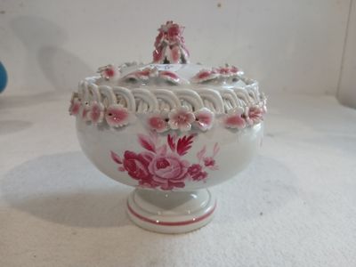 un bol blanc orné de fleurs roses, posé sur une table