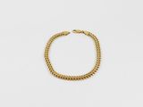 un bracelet en chaîne en or sur fond blanc