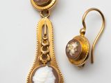 gros plan d'une paire de boucles d'oreilles sur une surface blanche