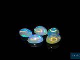 three white oplites on a black surface with a black background