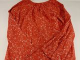 a close up of a red top with a floral pattern
