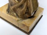 bronze statue of a woman holding a cup on a marble base