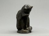 une petite statue représentant un ours assis sur une assiette