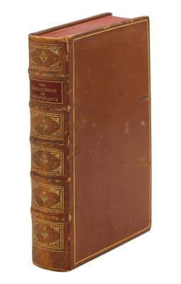 un vieux livre à la couverture brune et à la bordure dorée