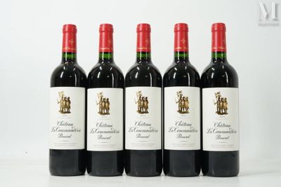 quatre bouteilles de vin rouge sont alignées sur une table