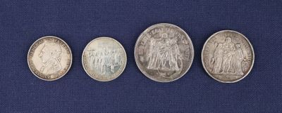 quatre types différents de pièces d'argent posées sur un tissu bleu
