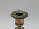 an antique brass candle holder on a white background
