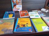 de nombreux livres posés sur une table, avec une souris en arrière-plan