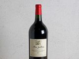 a bottle of red wine sitting on a wooden table
