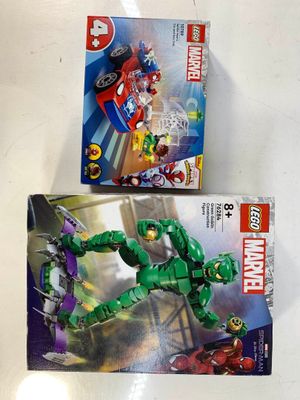 Deux boîtes de Lego sont posées l'une à côté de l'autre sur une table.