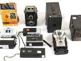 beaucoup de vieux appareils photo et d'autres objets sur la table