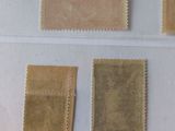 four different postages on a white surface with one stamp missing
