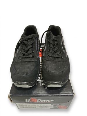 une paire de baskets noires posée sur une boîte, sur une surface blanche