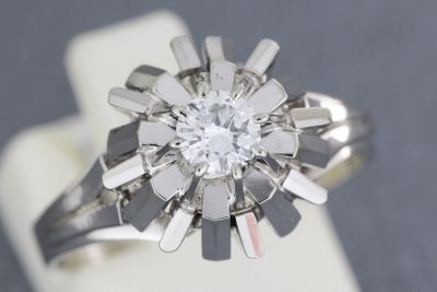 une photo d'une bague en diamant posée sur un présentoir à bagues
