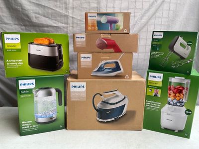 Plusieurs cartons contenant des appareils électroménagers Philips sont empilés les uns sur les autres.