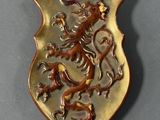 a gold plate with a lion on it on a gray surface